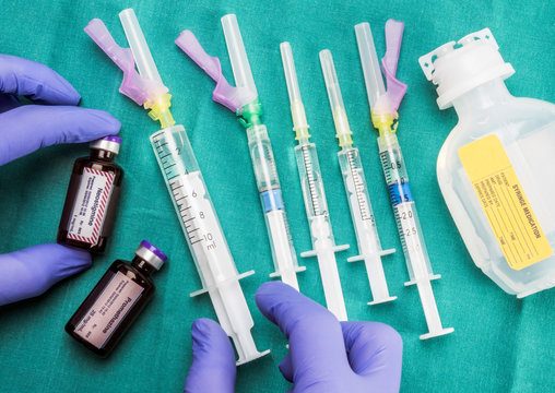 Nurse preparing hospital medication, Left hand holding a vial of neostigmine, conceptual image, horizontal composition