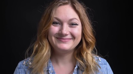 Closeup portrait of adult caucasian blonde woman smiling and nodding in token of approval while looking at camera