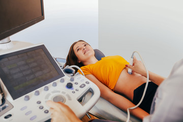 Doctor makes the patient women abdominal ultrasound. Ultrasound Scanner in the hands of a doctor....