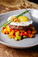 Beefsteak with grilled chicken egg and vegetable salad in a beautiful plate and restaurant serving