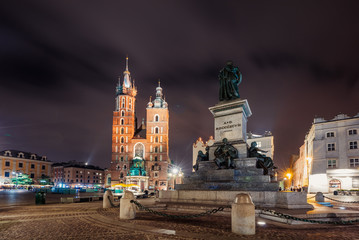 Obraz premium Adam Mickiewicz Monument on Main Market Square in front of St. Mary's Basilica in Krakow, Poland at night