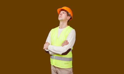 The man in a construction helmet and a vest looks in up