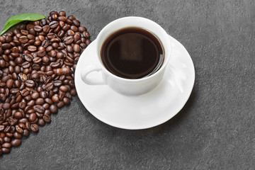 Coffee cup and saucer on a wooden table.vCoffee Beans