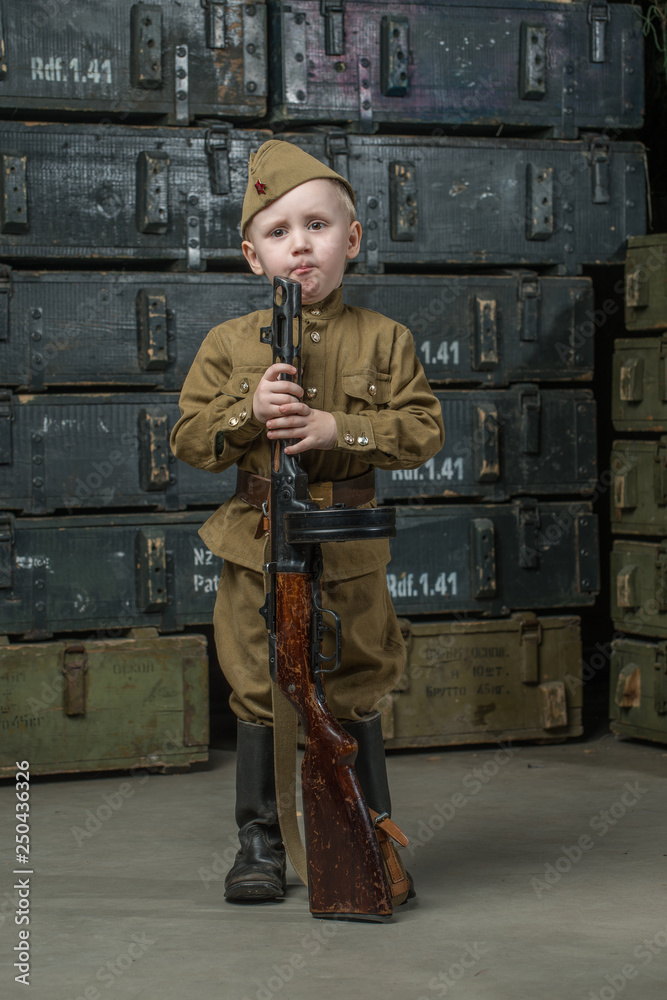 Wall mural The boy is dressed in military uniform