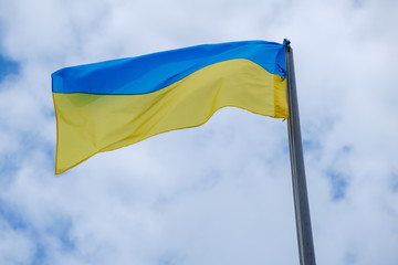 Ukrainian flag flies against sky.