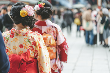Young girl wearing Japanese kimono standing in front of Sensoji Temple in Tokyo, Japan. Kimono is a Japanese traditional garment. The word "kimono", which actually means a "thing to wear"
