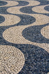 Playing with different shapes and patterns of a cobbled street of Lisbon (Portugal). The black and white stripped cobbled