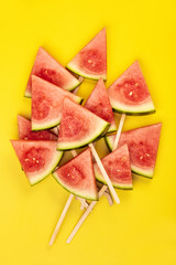 Slices of watermelon on yellow background, flat lay