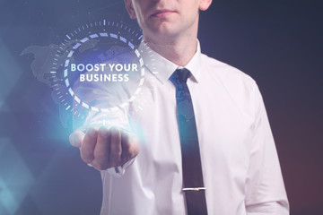 The concept of business, technology, the Internet and the network. A young entrepreneur working on a virtual screen of the future and sees the inscription: Boost your business