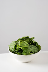 raw spinach leaves in a white bowl
