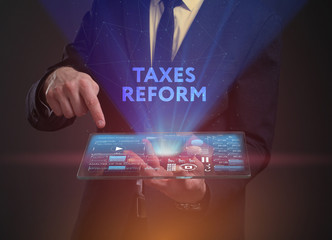 The concept of business, technology, the Internet and the network. A young entrepreneur working on a virtual screen of the future and sees the inscription: taxes reform