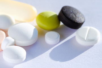 Pill tablet multicolor medicine lying isolated on white, extreme close-up macro.