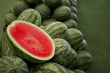 Fresh watermelon sliced on heap for sale in market with copyspace.