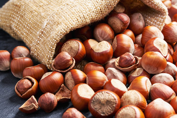 Pistachios   in bag on black table. Heap or stack of pecan .