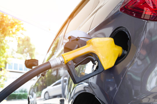 Gasoline gas nozzles refueling gas tank in car oil station.