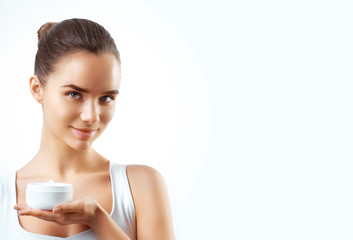 portrait of beautiful woman applying some cream to her face for skin care