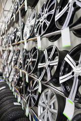 Brand new clean modern rims on the shelves in a car shop.