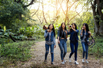 Trekking holiday concept.Four women are trekking in the mountains with backpack,tent,hiking...