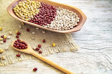 Variety of beans on wooden spoon on wooden background. mung beans, peanuts, red beans and brown beans.