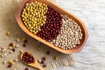 Variety of beans on wooden spoon on wooden background. mung beans, peanuts, red beans and brown beans.