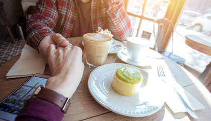 man and woman sit in a cafe at a table