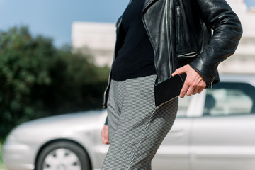 Close up on person hold keeping cellphone in the pocket, outdoors automobile transportation...