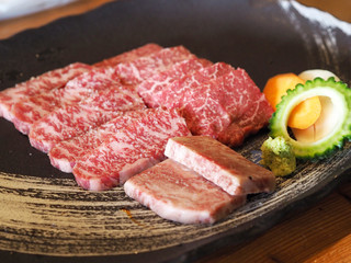 A few piece of meat with veggies were ready on a ceramic plate for teriyaki in a Japanese restaurant