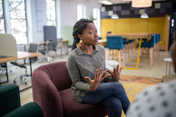 Job interview in co-working space by recruiter. Black african woman in her twenties being...