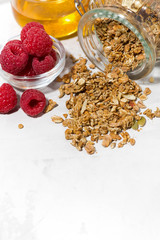 sweet granola in a jar, fresh raspberries and honey, vertical closeup
