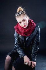 young girl in black leather jacket on a dark background in the studio