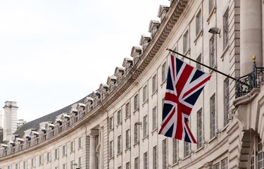 Gordijnen British flag on the background of the historic building of London, UK © Mary