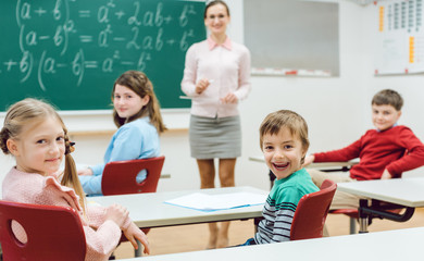 Schüler in der Klasse melden sich, um eine Frage zu beantworten 