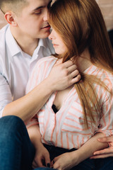 Fototapeta premium beautiful couple, the guy and the girl, lie at home in bed, kiss