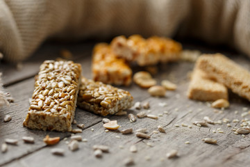 Assorted kozinaki, on old vintage background, with burlap fabric. Country style. Delicious sweets from the seeds of sunflower, sesame and peanuts, covered with shiny glaze.