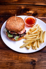 tasty hamburger with french fries and ketchup on a white plate