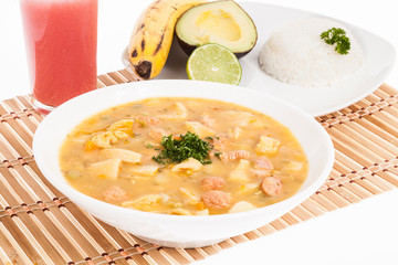 tasty typical Colombian food; Mondongo of soup with avocado, banana and white rice