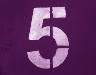 Number 5 in stencil on metal wall in purple tone.