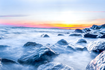Long exposure of rocky shore over sunset