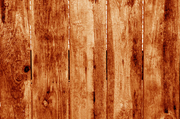 Weathered wooden fence in orange color.