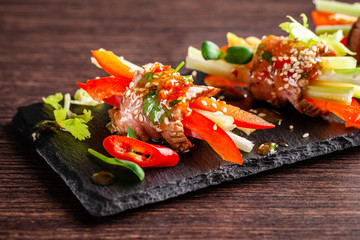 Concept of European cuisine. Snack for wine. Raw veal roll with crispy vegetables, cucumber,...