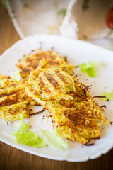 grilled potato pancakes in a plate, on a wooden table