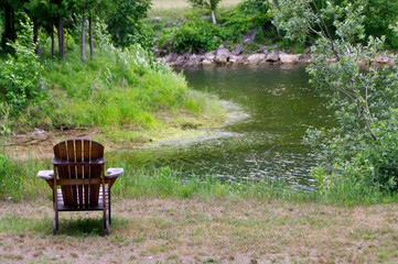 Adirondack chair looking over pond in summer 