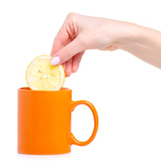 Slice lemon put in orange cup mug of tea on white background isolation