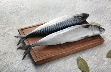 Board with raw mackerel fish on table