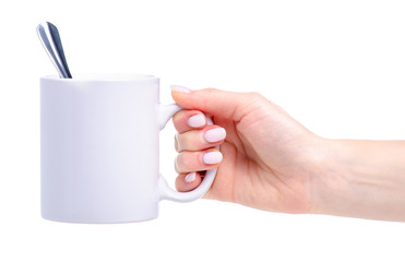 White cup mug with tea spoon in hand on white background isolation