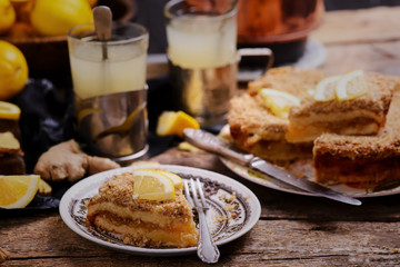 Pieces of lemon pie on a plate and tea in glasses