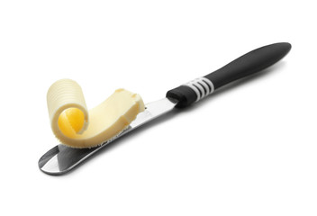 Knife with butter curl on white background