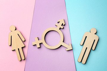 Female and male figures with symbol of transgender on color background