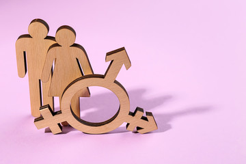 Female and male figures with symbol of transgender on color background