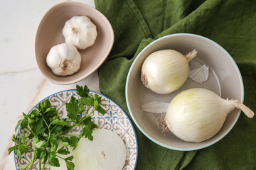 Raw onion with garlic and herbs on light table © Pixel-Shot